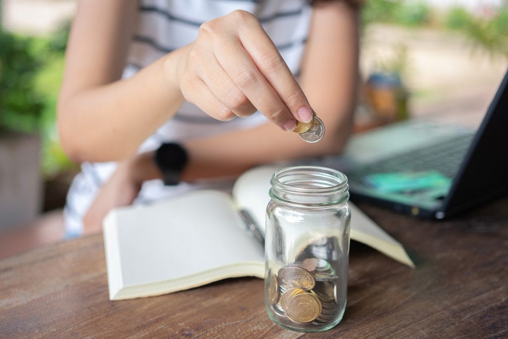 Woman Putting Money Into Her Emergency Funds